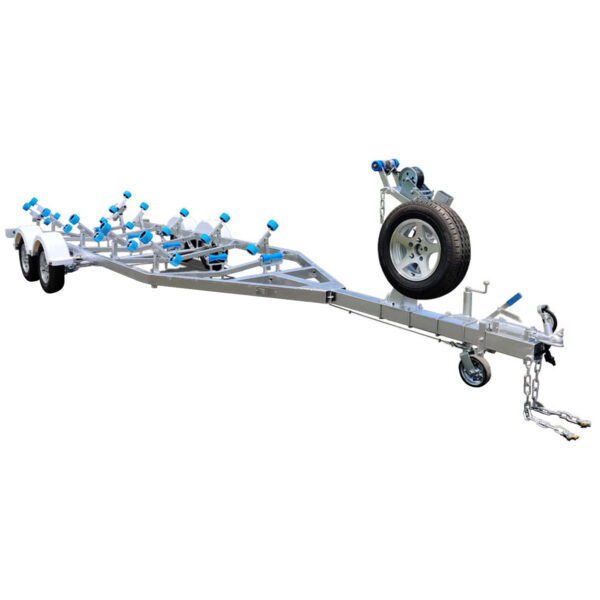 A silver boat trailer with multiple blue rollers and a metal frame, designed to support and transport boats. It has dual axles, a mounted spare tire, and a front wheel for easy maneuvering, with chains and hooks for securing.