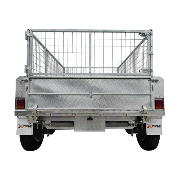 A rear view of the 8×5 Dual Axle Hydraulic Tipper Tandem Box Trailer (3500KG ATM) with wire mesh top, diamond plate surface, two wheels, red side reflectors, and XTREME on the mud flaps is shown.