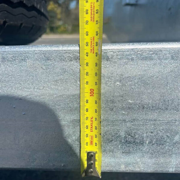 A yellow tape measure shows about 100 cm in height on the metal surface of the 8×5 Dual Axle Hydraulic Tipper Tandem Box Trailer - 3500KG ATM With Ramp Holders. A tire appears in the upper left corner of the image.