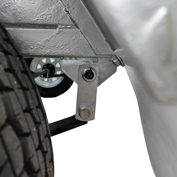 Close-up of a metal bracket and bolt connecting the leaf spring suspension to the frame of a 6x4 Single Axle Box Trailer ATM 750KG With Jockey Wheel, with a tire and wheel visible on the left.