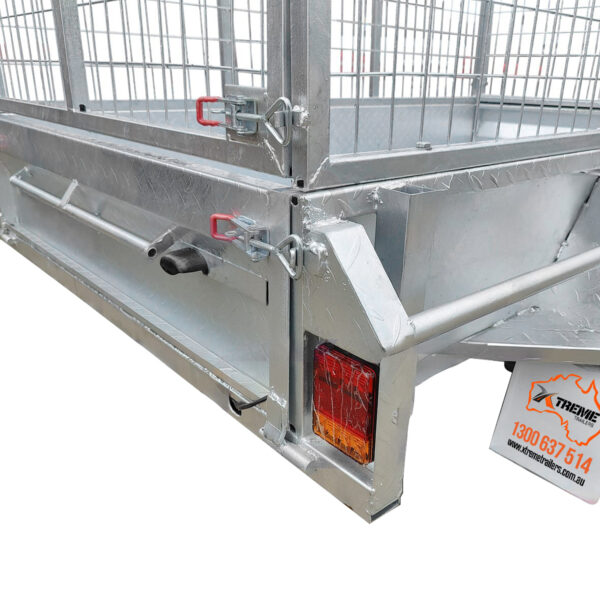 Close-up of the rear corner of an 8x5 Single Axle Box Trailer ATM 750KG With Jockey Wheel, showing the mesh gate, latch mechanisms, red and amber tail light, and trailer license plate sign.