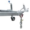 Close-up of a Premium 10x5 Dual Axle Heavy Duty Tandem Trailers metallic hitch with coupling. A chain dangles, a caster wheel is part of the frame, and a blue handle on the left likely operates the jack stand.