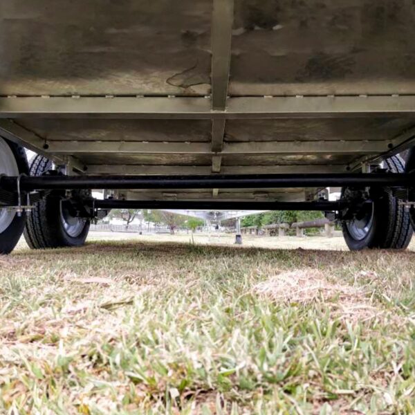 A close-up view shows the metal frame and wheels of the Premium 8x6 Dual Axle Heavy Duty Tandem Trailer (2000KG ATM), positioned on short grass outdoors.