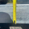A 7.5m Galvanized Dual Axle Boat Trailer with 3500kg ATM, perfect for boats from 6.8m to 7.5m, is shown with a yellow tape measure vertically against its slightly weathered surface, indicating around 100 cm. A shadow and part of a wheel are visible in the background.
