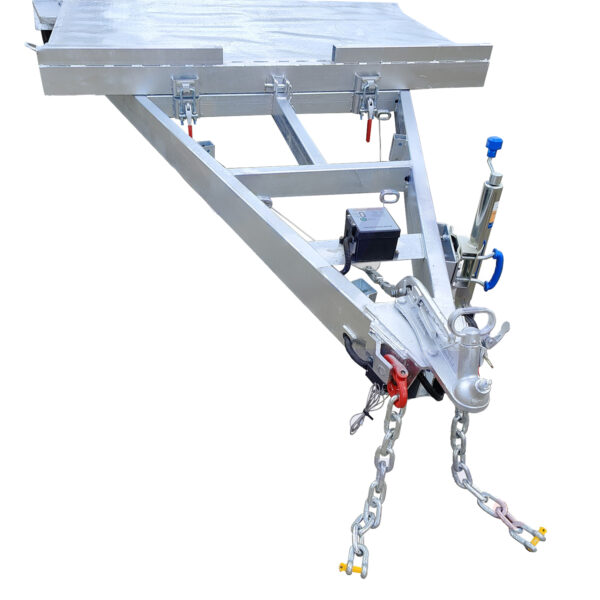 Close-up of the front end of the Dual Axle Premium 3500KG Car Trailer, featuring a triangular hitch with coupler, safety chains, a jack, and securing mechanisms. Crafted from metal for hauling heavy loads on its 16.4×6.6FT (5x2M) deck.