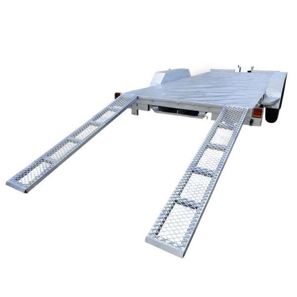 A silver Dual Axle Premium 3500KG Car Trailer features two extending metal ramps at the rear, a grated surface, and partially visible wheels on each side. The trailer boasts a spacious 16.4×6.6FT (5x2M) deck and is made of metal.