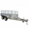 The 10×6 Dual Axle Hydraulic Tipper Tandem Box Trailer - 3500KG ATM With Ramp Holders is a dual-axle utility trailer featuring a robust metal frame, flatbed with mesh sides, and a towing hitch with safety chains for hauling heavy loads.