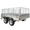 The 10×6 Dual Axle Hydraulic Tipper Tandem Box Trailer - 3500KG ATM with Ramp Holders is a silver utility trailer featuring tall wire mesh sides, a sturdy solid base, a front hitch, and dual wheels with black tires and white rims—ideal for transporting goods securely.