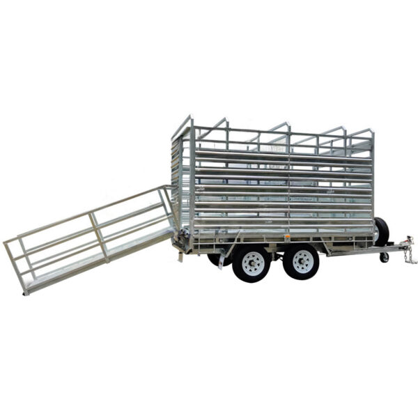 The 12x7 Dual Axle Flat Top Cattle/Livestock Trailer has a silver finish, features two wheels on each side, an open design with metal bars, side rails, a ramp for loading animals on the left side, and a front hitch for towing. It has a 3500KG ATM capacity.