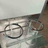 The 3.8m Big Box Food Trailer features a metal stand with two circular brackets suitable for tanks or drums. It sits on a diamond plate surface with a simple frame and clamps for secure holding, reflecting light for a shiny appearance.