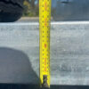 A yellow measuring tape shows about 180 mm when placed vertically from the top to the bottom edge of the 14x7 Dual Axle Hydraulic Tipper Tandem Box Trailer - 4500KG ATM With Ramps, aligned against its metallic surface.