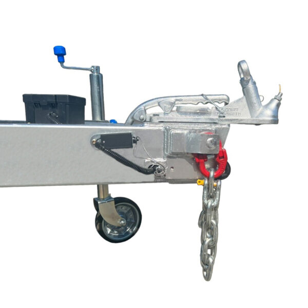 Close-up of the Premium 10x7 Galvanized Flat Top Trailer with 4500KGS ATM (Pre-order) featuring a metal trailer hitch with a hand crank, black storage box, wheel, red safety latch, and heavy-duty safety chain against a white background.