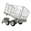 The Premium 12×7 Hydraulic 3-Way Tipper Galvanised Flat Top Trailer 4500kg ATM (Pre-order) is shown with its bed tilted upward in a dumping position. This metal tandem trailer features mesh sides, dual wheels on each side, and a metal toolbox mounted at the front.