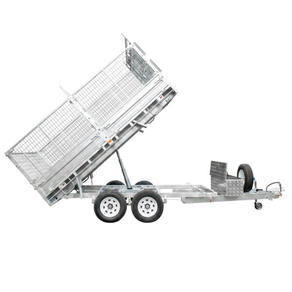 The Premium 12×7 Hydraulic 3-Way Tipper Galvanised Flat Top Trailer 4500kg ATM (Pre-order), a dual-axle silver utility trailer with wire mesh sides, is shown tilted upward for dumping. It features a spare tire mounted on the front and a metal storage box positioned near the hitch.