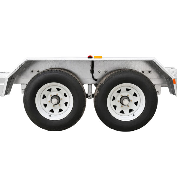 Side view of the Premium Hydraulic Tipper Car Trailer 4200kg ATM 16.4×6.6FT (5x2M) Deck Size (Pre-order), constructed from metal with a silver finish and equipped with two black rubber tires featuring white rims. The trailer is positioned against a white background, showcasing red and yellow reflectors above the wheels.