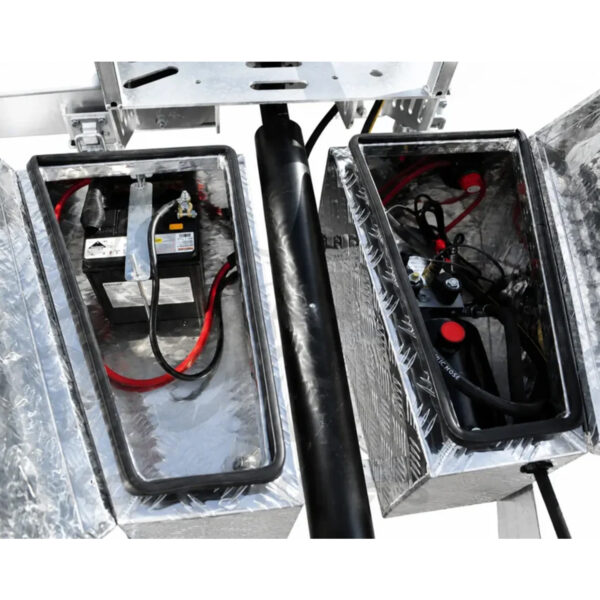 Two open metal compartments of the Premium Hydraulic Tipper Car Trailer 4200kg ATM 16.4×6.6FT (5x2M) Deck Size show a battery with cables on the left and mechanical components, wires, and fluid reservoirs on the right. The interior features a reflective lining.