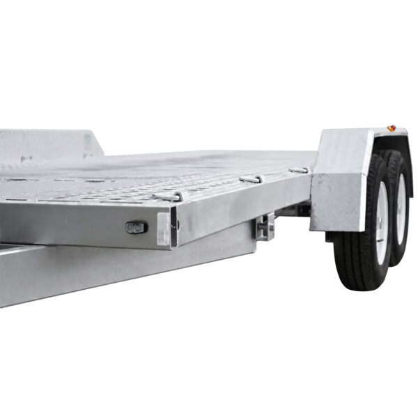 Close-up view of the Premium Hydraulic Tipper Car Trailer 4200kg ATM 16.4x6.6FT (5x2M) Deck Size with a punched floor, featuring dual wheels and wheel fenders, photographed from a low angle against a white background.