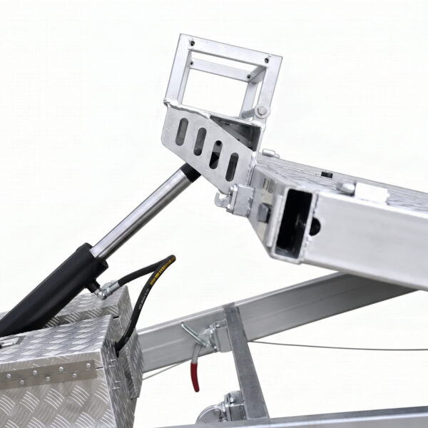 Close-up of the Premium Hydraulic Tipper Car Trailer 4200kg ATM 16.4x6.6FT (5x2M) Deck Size - Punched Floor (Pre-order), showcasing its mechanical hydraulic system with a metal piston, connecting rods, and a textured metal box with attached hoses, all set against a plain white background.
